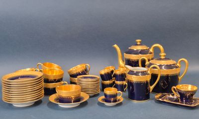 une image représentant un service à thé bleu et or, avec des tasses et des soucoupes