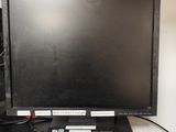 un écran d'ordinateur noir posé sur un bureau, à côté d'un clavier
