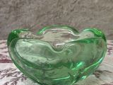 un saladier en verre vert posé sur une table