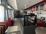 des tables et des chaises dans un restaurant où le menu est affiché au mur