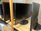 two monitors sitting on a shelf next to each other