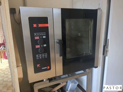 un four argenté et noir posé sur un support dans une cuisine