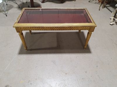 une table basse avec un plateau en verre dans une pièce