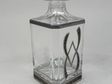an image of a small glass bottle with a spoon and spoon rest