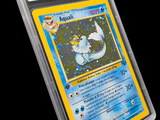 La carte Pokémon se trouve dans un étui en plastique transparent sur fond noir.