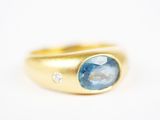 Gros plan sur une bague en or ornée d'une topaze bleue
