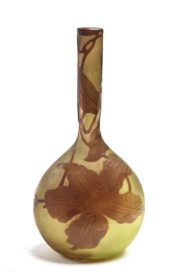 un vase en verre orné d'une fleur, posé sur une surface blanche