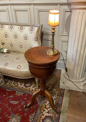 a living room with a couch and a table with a lamp on it