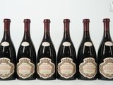 six bouteilles de vin sont alignées sur une table