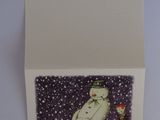 a white card with a picture of a snowman and a bottle of wine