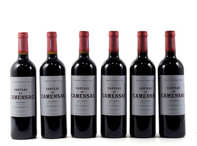 six bottles of wine are lined up in a row on a white surface