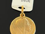 gold plated medallion of a woman ' s head with a name tag