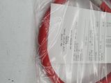 a red hose that is wrapped in plastic on a table