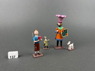 two figurines of a woman with a dog and a man with a sign