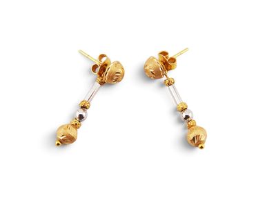 a pair of gold earrings with black beads on a white background