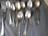 a lot of silver spoons and forks on a table