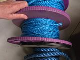 une personne qui tient une bobine de corde bleue
