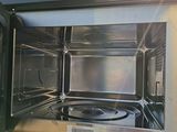 a stainless steel microwave oven with the door open