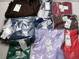 de nombreux t-shirts de différentes couleurs posés sur une table blanche