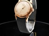 une image d'un gros plan d'une montre-bracelet sur une surface noire