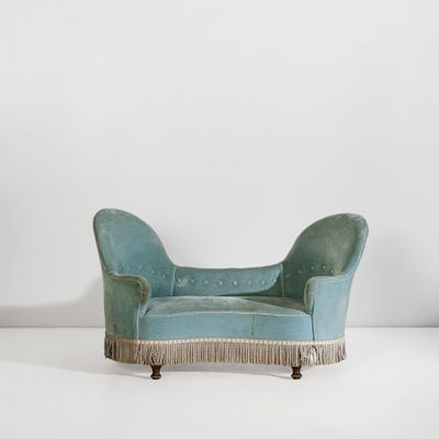 une chaise longue en velours bleu avec des franges sur les pieds
