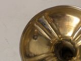 a gold candle holder on a white table