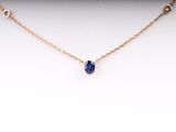 a necklace with a blue sapphire stone on a gold chain