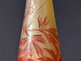 a glass vase with a red and yellow design on it