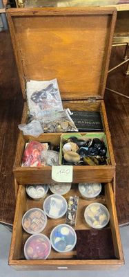 une boîte en bois remplie d'objets divers, posée sur une table