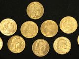 a close up of a bunch of gold coins on a black surface