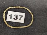 un gros plan d'un bracelet en or sur lequel figure un numéro