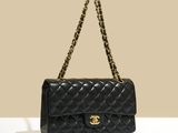 un sac Chanel noir posé sur une surface blanche