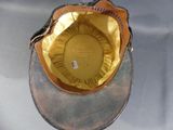 a baseball cap with a gold visor on a table