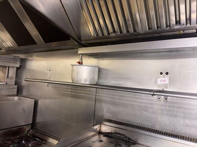 a large stainless steel kitchen with a stove and oven
