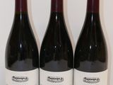 trois bouteilles de vin sont alignées sur une table