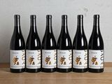 six bouteilles de vin sont alignées sur une table en bois