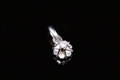 a close up of a diamond ring on a black surface