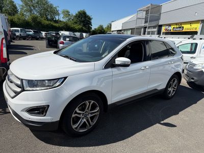 Une Ford Edge blanche est garée sur un parking avec d'autres voitures