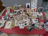 une table recouverte d'une nappe rouge sur laquelle sont posées de vieilles photos