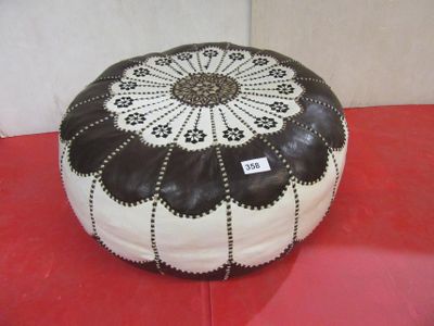 a black and white pouffe sitting on a red surface
