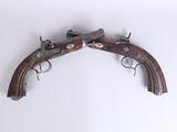 an old pair of pistols on a white surface with a white background