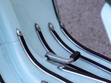 a blue scooter with black and white stripes parked on the street