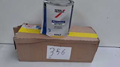 un pot de peinture posé sur une boîte en carton