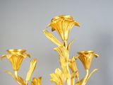 a gold vase with flowers in it sitting on a table