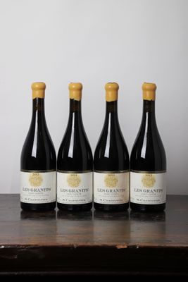 quatre bouteilles de vin posées sur une table en bois
