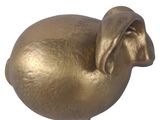 a gold pig figurine sitting on a white surface