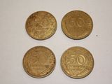 four gold coins sitting on top of each other on a white surface