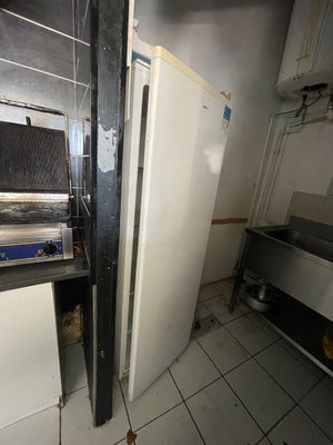 une image d'une cuisine avec une cuisinière et un réfrigérateur