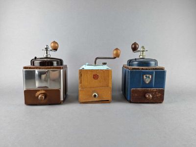 three different types of coffee grinders on a gray surface