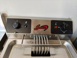 a close up of a fryer with a frying pan on it